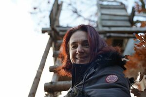 Frau klettert die Leiter zu einem Hochsitz hinauf