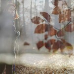 Doppelbelichtung Frau auf Waldweg mit Buchenblättern im Vordergrund