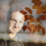 Buchenblätter an einem Zweig mit Frau im Hintergrund