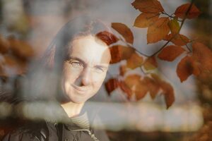 Buchenblätter an einem Zweig mit Frau im Hintergrund