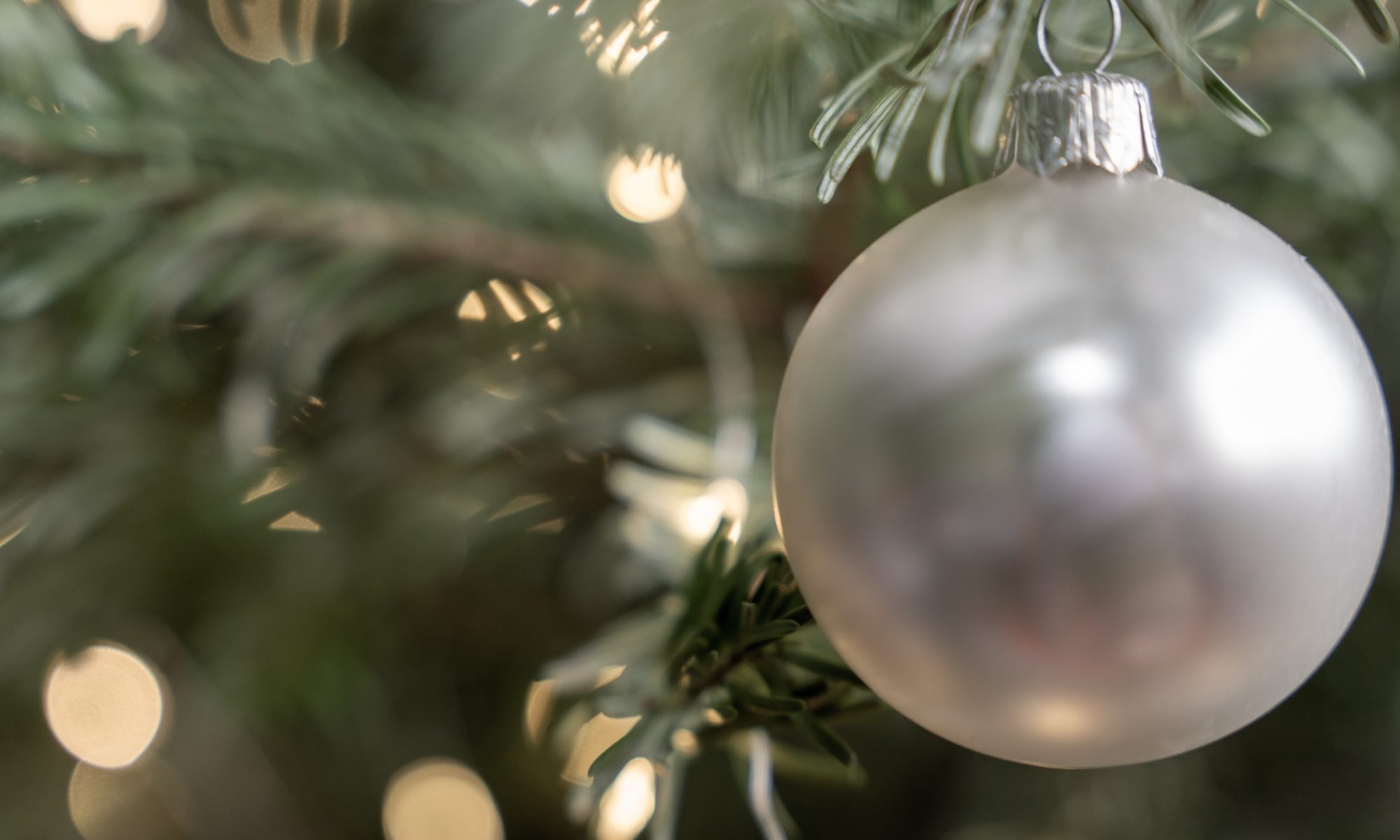 Eine Weihnachtskugel am Weihnachtsbau mit niedriger Sättigung